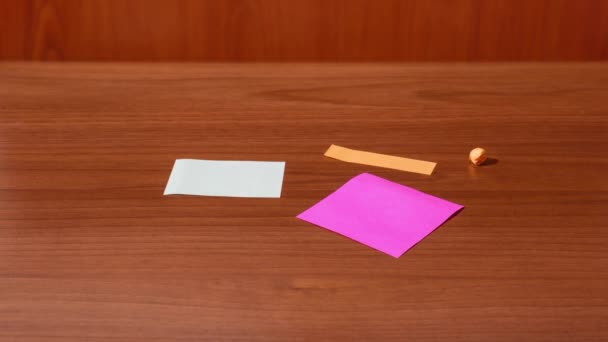 Nota papel aparece en la mesa en stop motion — Vídeo de stock