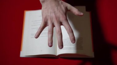 El, telekinezi ile kitabın sayfalarını karıştırıyor.