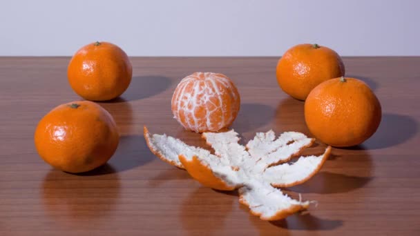 Tangerines mengupas kulit dan dibagi menjadi irisan dalam gerakan berhenti — Stok Video