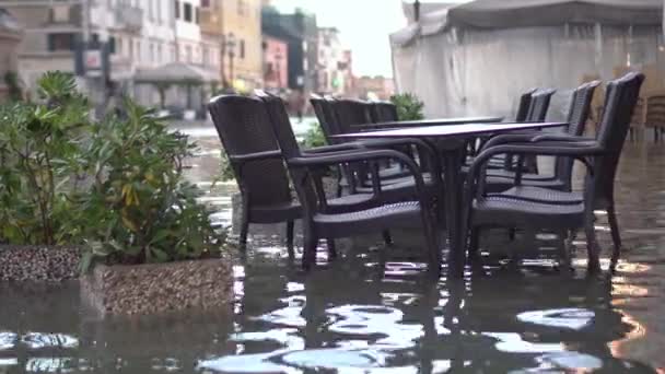 Bar chairs and tables in the flooded city — Stock Video