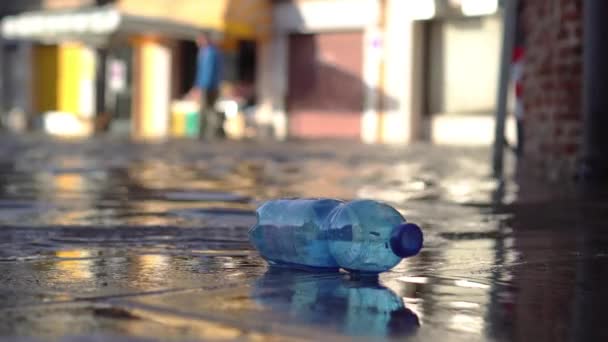 Su basmış şehirde plastik şişe. — Stok video