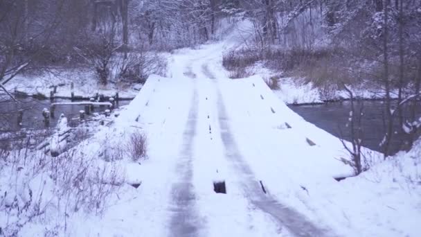 Gammal bro över ån är täckt med snö — Stockvideo