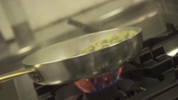 A kagylókat tűzzel égetik a serpenyőben. — Stock videók