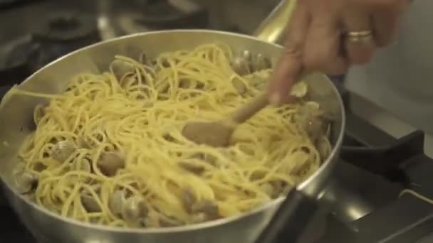 Молюски з макаронами, змішаними на сковороді — стокове відео