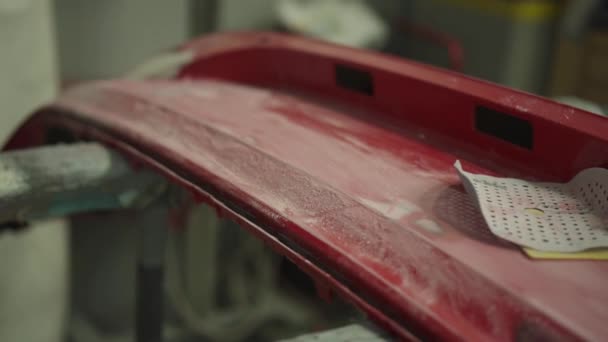 Rode bumper van de auto bij verwerking door de carrosseriewerkplaats — Stockvideo