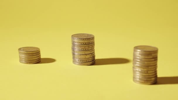 Münzen wachsen in Gruppen auf gelbem Hintergrund — Stockvideo