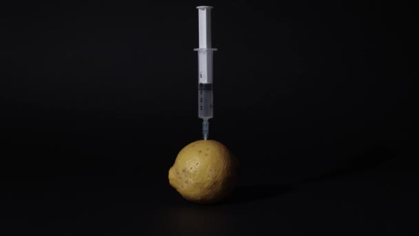 Шприц делает инъекцию в лимон — стоковое видео
