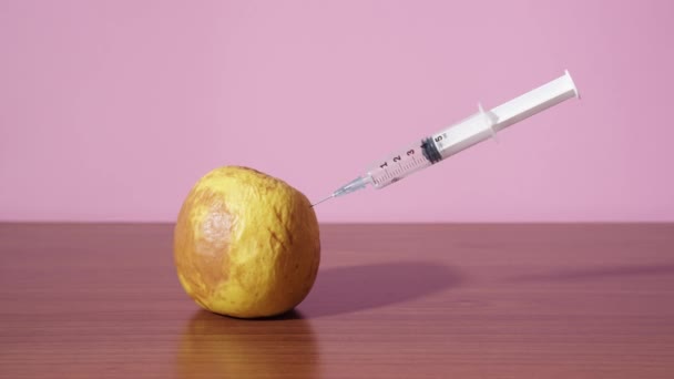 Syringe gives an injection into the rotten green apple — 비디오