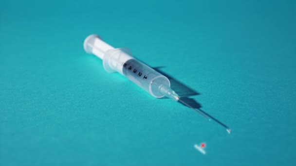 Injekční stříkačka vytlačuje protilátku na modrém pozadí — Stock video