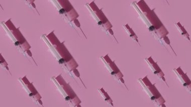 Many syringes move on a pink background