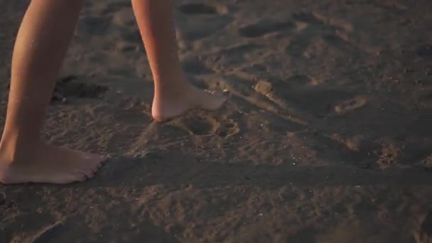 Meisje loopt blootsvoets op het zand breken van een gebouw — Stockvideo