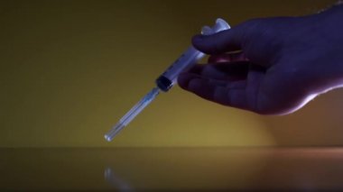 El parmaklarındaki şırıngayı çevirir.