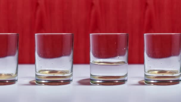 Water fills glass cups in stop motion — Stock Video