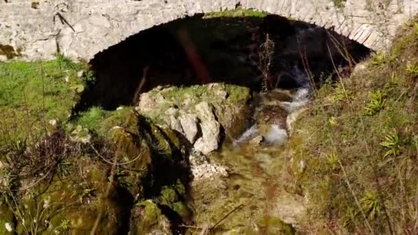 Starożytny most skalny przez mały strumień — Wideo stockowe