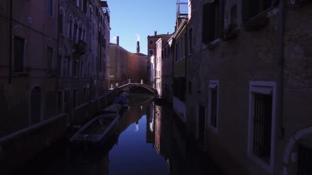 Un canal en Venecia con barcos y puente — Vídeo de stock