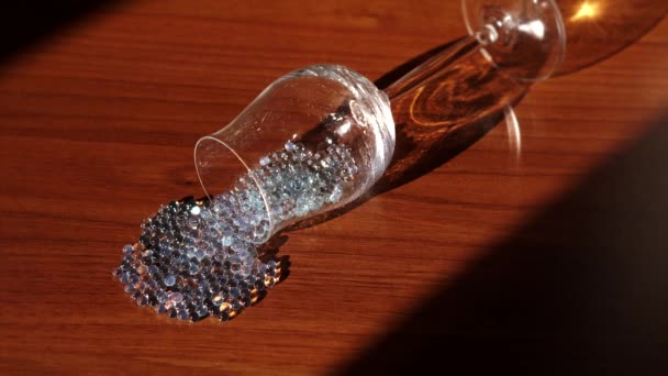 Gems come out of a glass chalice — Stockvideo