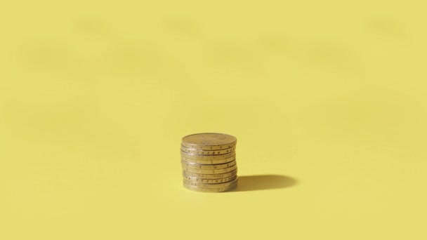 Münzen erscheinen auf gelbem Hintergrund — Stockvideo