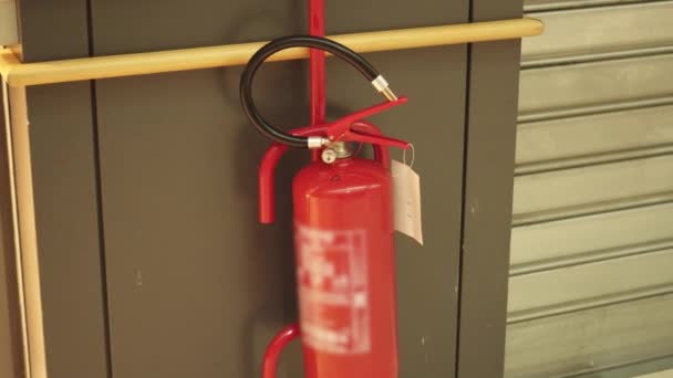 Röd brandsläckare hängande på väggen — Stockvideo