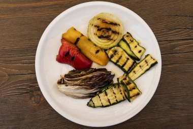 Koyu ahşap arka planda ızgara sebzeli diyet vejetaryen salatası.