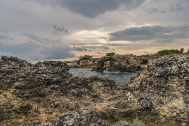 Vahşi doğanın panoramik manzarası, Akdeniz 'in mavi kristal suyu ve gün batımında Sicilya' nın Syracuse eyaletindeki Ognina sahilinde kayalık kıyı şeridi.