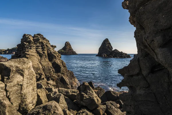 Volcanic rocks, big stones in the water, known as the Cyclopean Isles on the eastern coast of Sicily in the Mediterranean sea