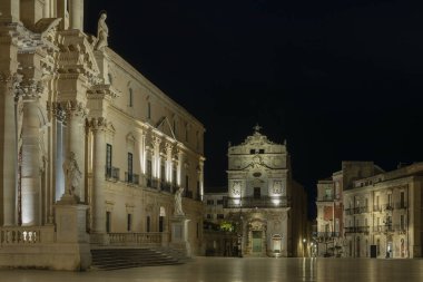 Ortygia adasının ana meydanı (Piazza Duomo) ve Sicilya 'daki Syracuse şehrinin gece yarısı Saint Lucia alla Badia Katolik kilisesinin cephesi.
