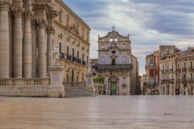 Ortygia adasının ana meydanı ve Badia 'daki Santa Lucia kilisesi Sicilya' nın Syracuse şehrinde bulutlu bir gündoğumunda.