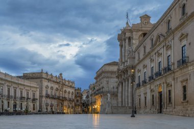 Sicilya 'nın Syracuse ilindeki mavi bulutlu gökyüzü ile gündoğumunda Sicilya barok örneği olan Ortygia adası ve Katedrali' nin tarihi meydanına bakın.