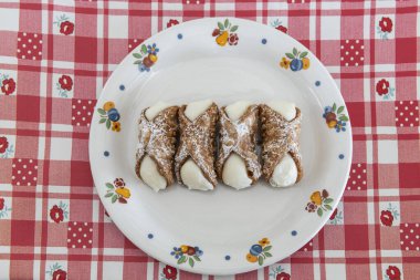 # Gurme ve geleneksel Sicilyalı tatlı Cannolo # # Ricotta peyniri ile dolu tabağın üzerinde #