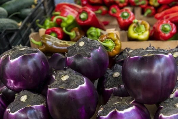 Fresh vegetables, eggplants and peppers, for sale in the colorful street, in local market of Ortigia island in province of Syracuse in Sicily