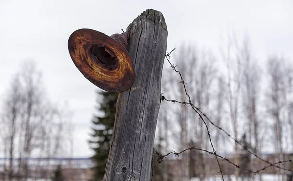 Old, rusty lantern on a fence with barbed wire. — Stock Photo, Image