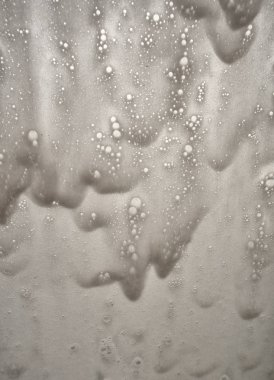 Odaklanamayan uçaklar cam parçalarını su damlalarıyla görür. Pistin yanındaki uçak penceresinde yağmur damlaları.