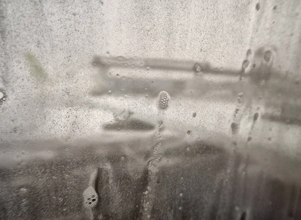 Samoloty bez skupienia oglądają szkło z kroplami wody. Krople deszczu na oknie samolotu przy pasie startowym. — Zdjęcie stockowe