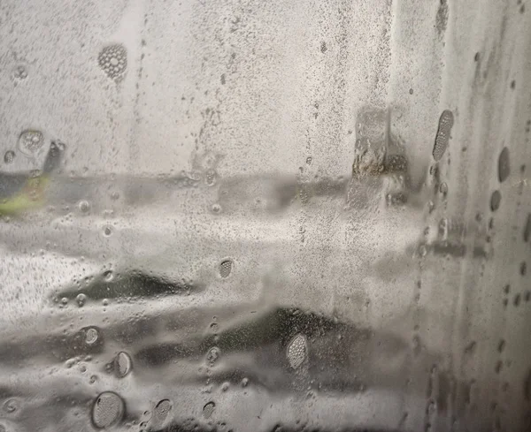 Odaklanamayan uçaklar cam parçalarını su damlalarıyla görür. Pistin yanındaki uçak penceresinde yağmur damlaları. — Stok fotoğraf