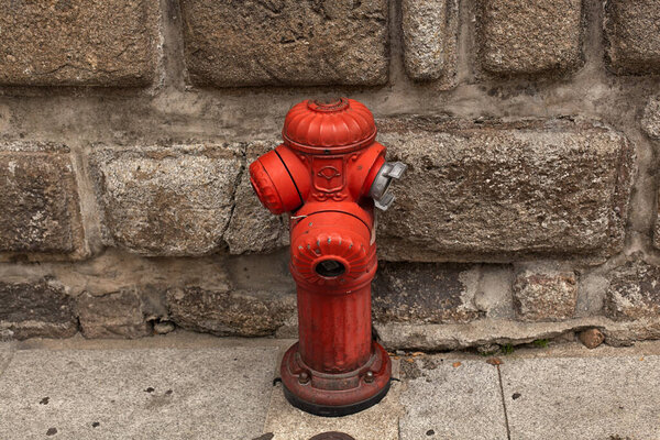 A red fire hydrant in a city setting.