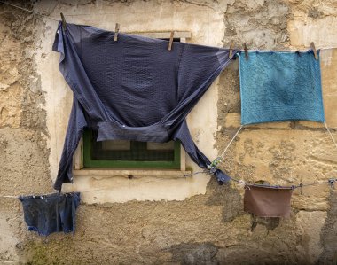 Pencerenin önünde birkaç sıra asılı kıyafet var..
