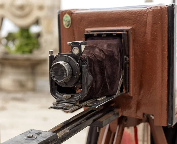 Vintage movie camera. An old movie camera stands on a wooden tripod.