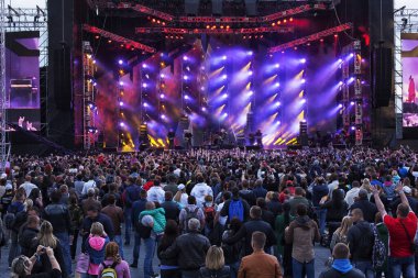 Parlak sahne ışıkları önünde bir konserdeki kalabalık..