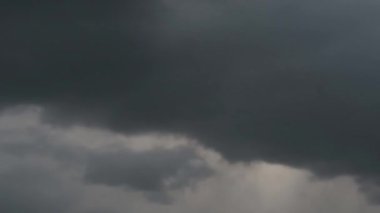 Gökyüzünde süzülen gri bulutların zaman turları. Bazen güneş bulutların arasından süzülür..