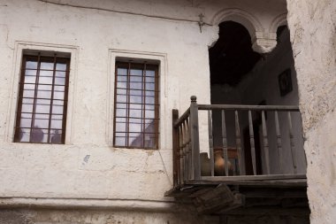 Güneşli bir günde bitkilerin ve çiçeklerin olduğu eski ilçede eski mimari dar bir cadde, Türkiye.