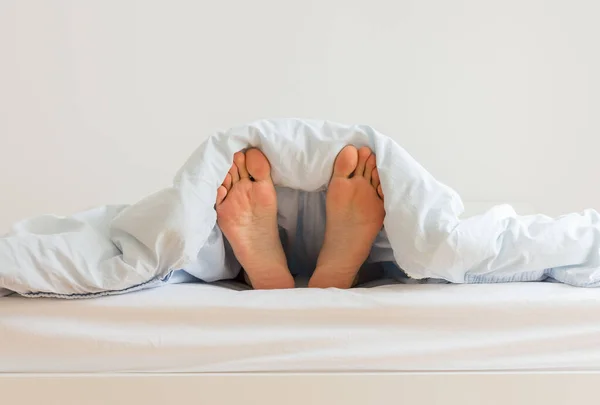 Мужчина спит на белой кровати — стоковое фото