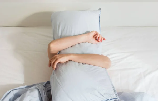 Frau schläft auf einem weißen Bett — Stockfoto