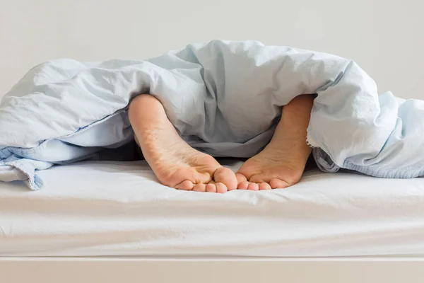 Мужчина спит на белой кровати — стоковое фото