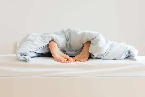 Mann schläft auf einem weißen Bett — Stockfoto