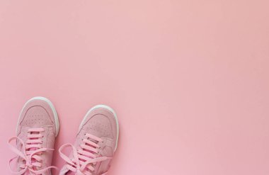 Pembe spor ayakkabıları pembe arka planda izole edilmiş.