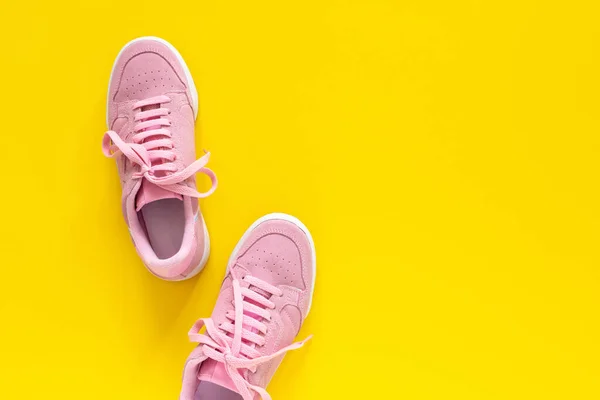 Pinkfarbene Turnschuhe auf gelbem Hintergrund — Stockfoto