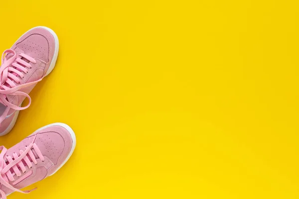 Pinkfarbene Turnschuhe auf gelbem Hintergrund — Stockfoto