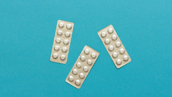 Blisterverpackungen mit Pillen auf blauem Hintergrund — Stockfoto