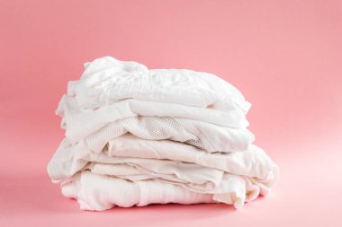 Pembe arka planda beyaz yaz kıyafetleri, izole edilmiş günlük giysiler.