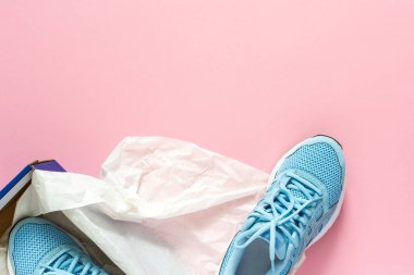 Pembe arka planda kutulu mavi spor ayakkabılar, yürüyüş ve spor için sezonluk ayakkabılar, fotokopi alanı, üst manzara